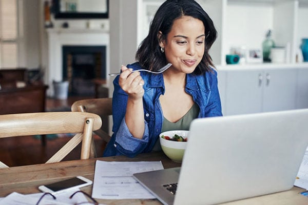 营养——拿着笔记本电脑的妇女吃健康早餐|加拿大克利夫兰诊所
