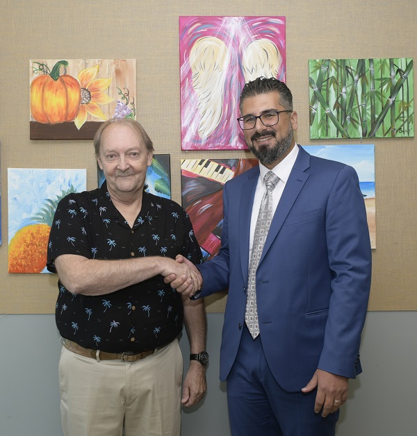 医学博士，克利夫兰诊所佛罗里达癌症研究所的区域研究主任Houssein Abdul Sater与第一位参加临床研究的患者Paul Weiss握手。