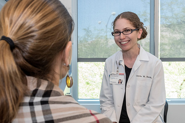 凯莉·赫什医生在内华达州克利夫兰诊所与一位多发性硬化症患者讨论治疗方案。